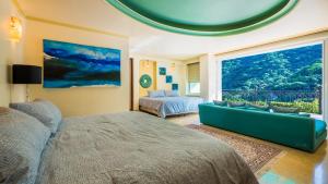 um quarto com uma cama, um sofá e uma janela em Boca de Tomatlán Ocean Frontage Boutique Hotel em Puerto Vallarta