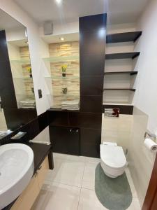 une salle de bain avec des toilettes blanches et un lavabo dans l'établissement Apartament Na Stoku, à Kielce 10 autres photos