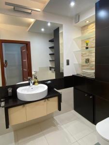 une salle de bains avec un lavabo et un miroir dans l'établissement Apartament Na Stoku, à Kielce