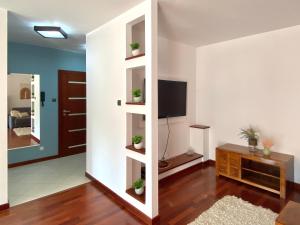un salon avec une télévision sur un mur dans l'établissement Apartament Na Stoku, à Kielce