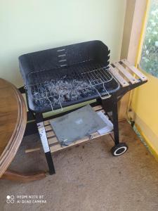 Una parrilla de carbón en una habitación con una mesa. en Kamp sv.Jovan, en Pirot