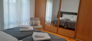 1 dormitorio con espejo, 1 cama y 1 silla en Erdizka, céntrico apartamento turístico con la mejor vista Plaza de los Fueros, en Estella