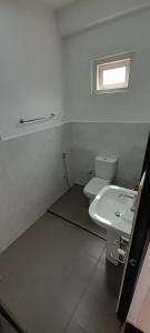 a bathroom with a white toilet and a sink at Lake Edge Resort in Anuradhapura