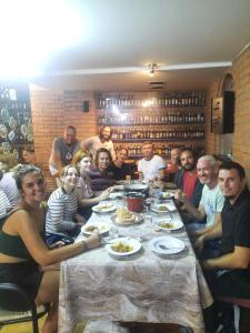 um grupo de pessoas sentadas à volta de uma mesa com comida em Hostel Iris em Belgrado