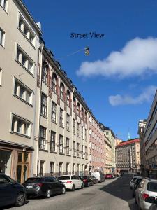 a street with cars parked on the side of a building at Stylish Studio at the Heart of Helsinki in Helsinki
