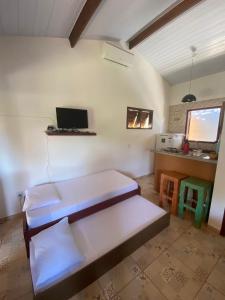 een kamer met 2 bedden en een bureau met een laptop bij Little Kamala in Pipa