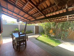 a patio with a table and a wooden pergola at Chalé Kamala com quintal - Perfeito para Nômades Digitais in Pipa +38 photos