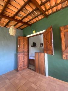 una camera con porte in legno e un letto in una stanza di Little Kamala a Pipa