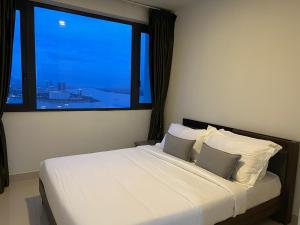 a bedroom with a bed with a large window at ImPian 2Br Condo in Phnom Penh