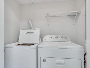 eine weiße Küche mit einem Herd und einer Waschmaschine in der Unterkunft Beach Bliss in Tybee Island