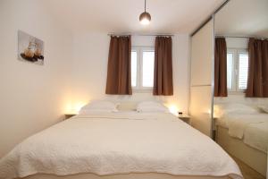 1 dormitorio con 1 cama blanca grande y espejo en Apartments My Place en Split