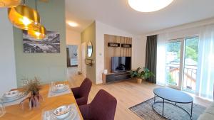 sala de estar con mesa, sillas y TV en Appartement - Penthouse Laimer, en Ebensee