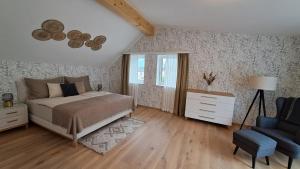 a bedroom with a bed and a chair at Appartement - Penthouse Laimer in Ebensee