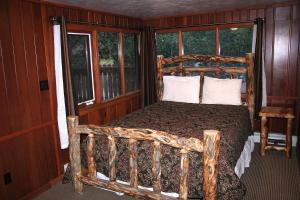 a bedroom with a wooden bed in a room with windows at Timber Creek Chalets- 14 chalet in Estes Park