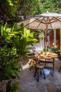 a table and chairs with an umbrella in a garden at Pousada Marendaz in Paraty