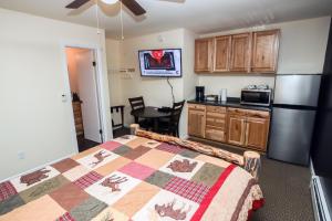 a bedroom with a bed and a kitchen with a refrigerator at Fawn Valley Inn- 294 condo in Estes Park