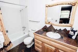 a bathroom with a sink and a toilet and a mirror at Fawn Valley Inn- 294 condo in Estes Park