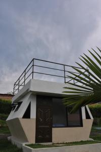uma pequena casa com uma varanda em cima em Cielo Abierto Glamping em San Gil