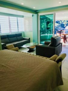 um quarto com uma cama e uma sala de estar em Boca de Tomatlán Ocean Frontage Boutique Hotel em Puerto Vallarta