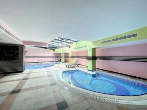 a large swimming pool in a large building at Time Place Tower - Vacationer in Dubai