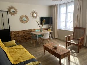 a living room with a couch and a table at L'appartement de Purdey in Saumur
