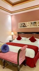 a hotel room with a large bed and a bench at Levant Hotel in Najran