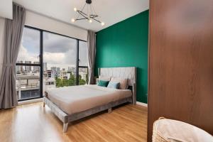 ein Schlafzimmer mit einem großen Bett und einer grünen Wand in der Unterkunft DingD0ng Home FelizEnVista 5-star facilities in Ho-Chi-Minh-Stadt