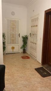 a hallway with a door and a potted plant at Cozy apartment in Ksar el kebir in Ksar el Kebir