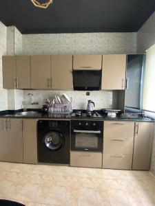 a kitchen with a stove and a washing machine at Cozy apartment in Ksar el kebir in Ksar el Kebir