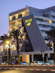 a large building with cars parked in front of it at Or suite sea side Eilat - אור סויט סי סייד אילת in Eilat