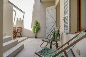 einen Balkon mit Stühlen, einem Tisch und einer Tür in der Unterkunft Sublime appartement avec Terrasse & Climatisation in Marseille