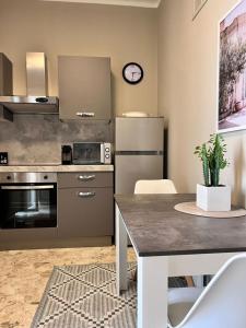 a kitchen with a table and a clock on the wall at Visconti 90 in Bari