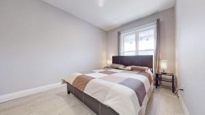 a bedroom with a large bed and a window at Newly Renovated 3 Bedroom in Hamilton