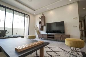 Il comprend un salon doté d'une télévision à écran plat et d'un canapé. dans l'établissement Luxury Prestigia 2Bed Rooms, à Rabat