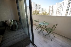 - un salon avec un canapé et une table sur un balcon dans l'établissement Luxury Prestigia 2Bed Rooms, à Rabat