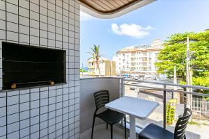 een tafel en stoelen op een balkon met uitzicht op de stad bij Predio com apartamentos completos, com piscina e a passos da praia - Agua Marinha in Florianópolis