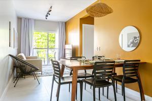 uma sala de jantar com uma mesa de madeira e cadeiras em Predio com apartamentos completos, com piscina e a passos da praia - Agua Marinha em Florianópolis