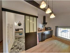 - une cuisine avec une grande porte coulissante dans une chambre dans l'établissement Appartement cosy et moderne Rodilhan, à Rodilhan
