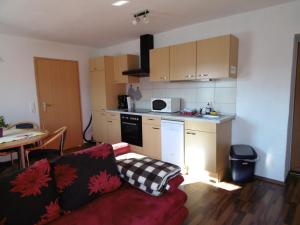 a living room with a couch and a kitchen at Ferienwohnung Schäfer in Waldbreitbach