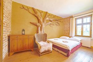 a bedroom with a bed with a tree mural on the wall at Farma Zelená Ruža in Kľačno