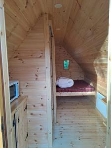 a small room with a bed in a wooden cabin at Camping Osuna in Madrid
