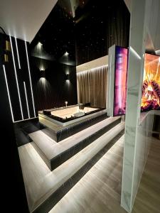 La salle de bains est pourvue d'une baignoire et d'un escalier avec une télévision. dans l'établissement Wiślane Tarasy VIP Apartamenty JACUZZI, à Cracovie