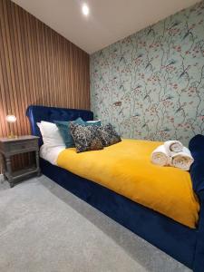 a bedroom with a blue bed with towels on it at Stylish Kent Gem - Free WiFi in Kent