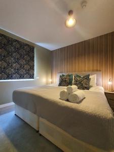 a bedroom with a large bed with towels on it at Stylish Kent Gem - Sleeps 6 in Kent