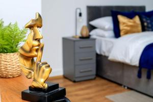 a statue of a woman playing a saxophone in a bedroom at Snuggle Inn - River view apartments - Close to O2 Arena, London Excel, London City Airport and Woolwich Ferry with parking in London