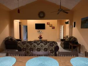 sala de estar con sofá y mesa en Full 3 BD Home w/Oceanviews and AC in all rooms., en Manchioneal