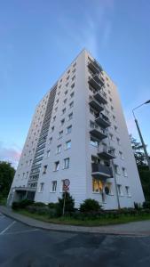 a tall white building with balconies on a street at Gold Glamour Apartment Sopot z dwoma sypialniami, duzy balkon in Sopot