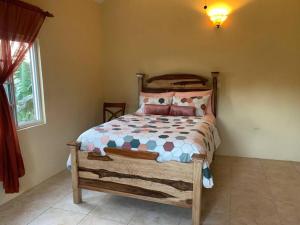 a bedroom with a wooden bed in a room at Full 3 BD Home w/Oceanviews and AC in all rooms. in Manchioneal