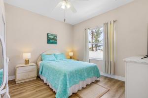 ein weißes Schlafzimmer mit einem Bett und einem Fenster in der Unterkunft Newly Renovated Villa with Heated Pool! - Villa Taina - Roelens Vacations in Cape Coral