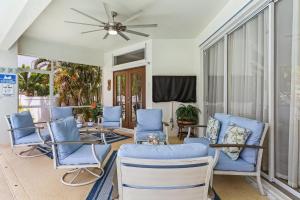 ein Wohnzimmer mit blauen Stühlen und einem Deckenventilator in der Unterkunft Newly Renovated Villa with Heated Pool! - Villa Taina - Roelens Vacations in Cape Coral